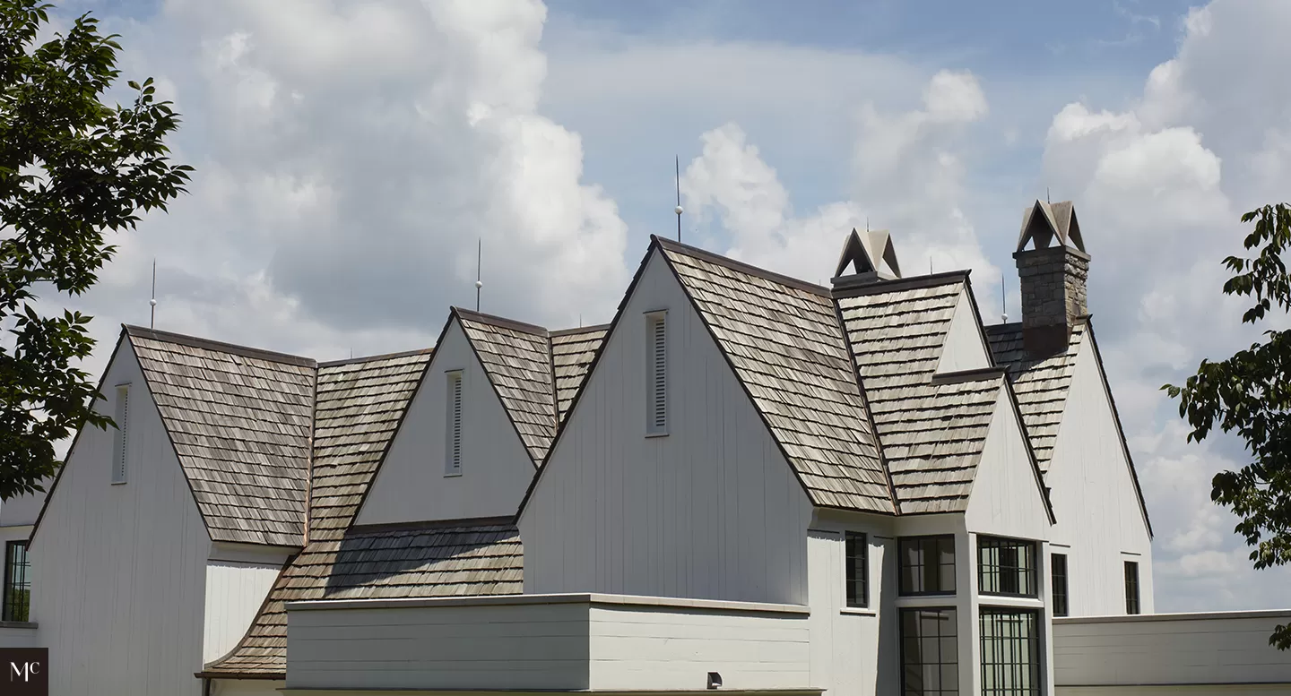 A large, white New England-style mansion with a gable roof