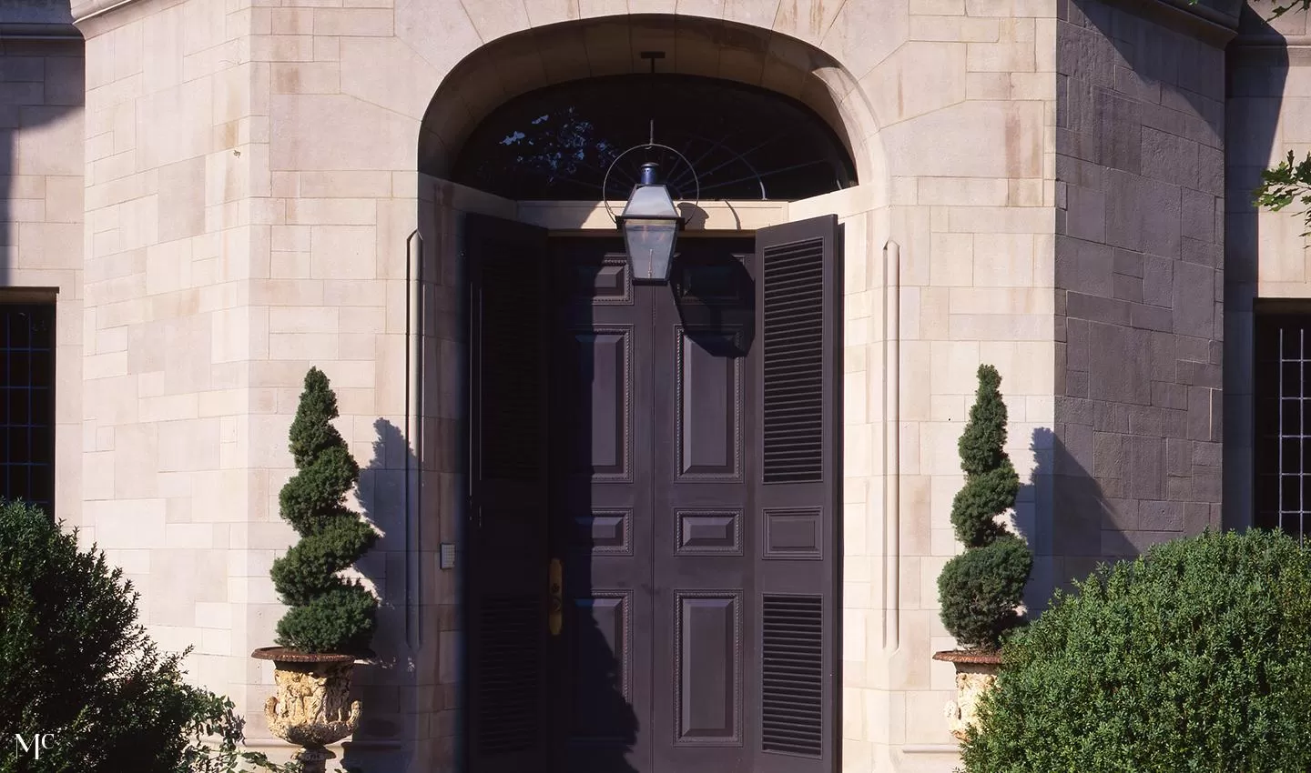 stone and stucco home with a circular wall, front door