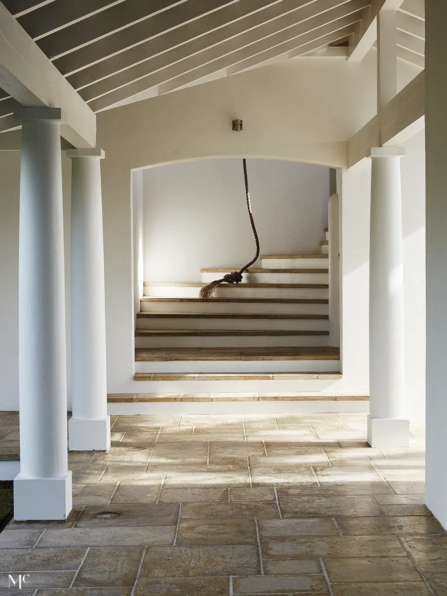 White and neutral tones of a stairway with large columns leading to it