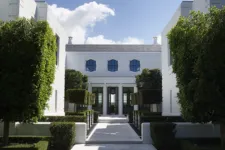 A symmetrical view of the front entrance to an all-white modern mansion with large black windows