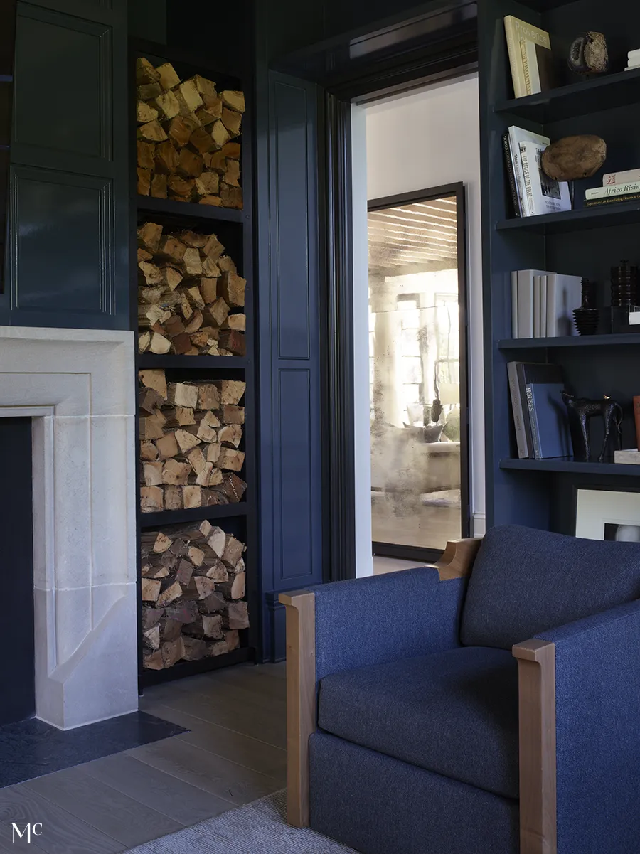 A reading room with dark blue bookshelves and furniture with wood