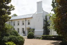 A large white house with double windows and shutters