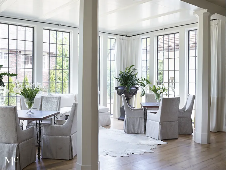 Room with white tables and chairs and large columns