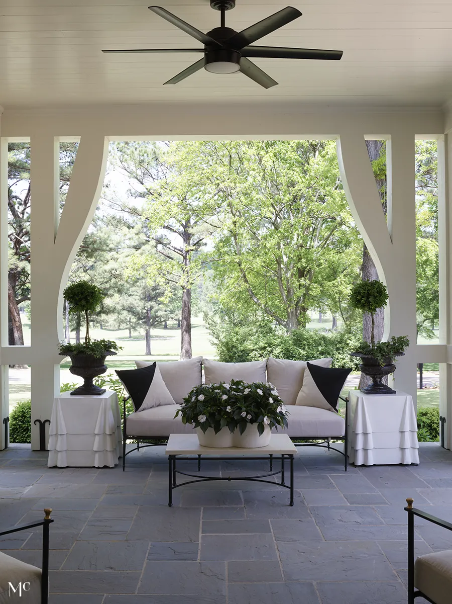 back patio with white furniture and greeneries