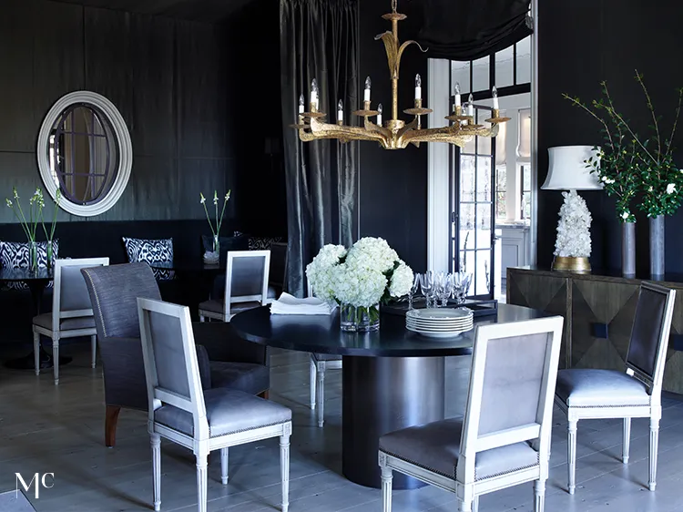 A large living room with black walls, white and silver accents