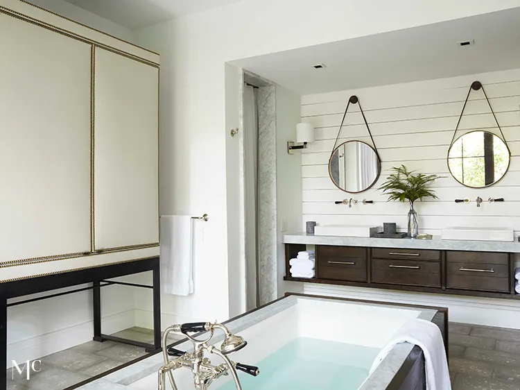 A modern bathroom with white walls and a large tub in the middle