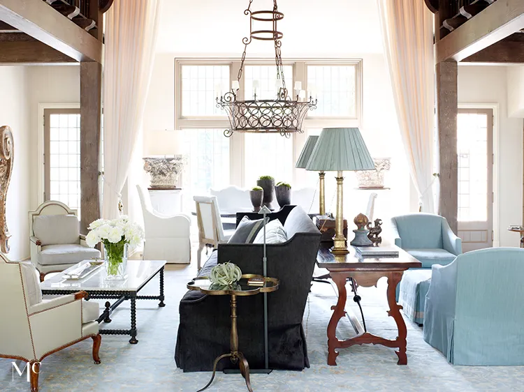 Elegant living room in the style of English country style, with a light blue sofa and armchair, a wooden coffee table on the left side, a grey carpet floor, tall windows