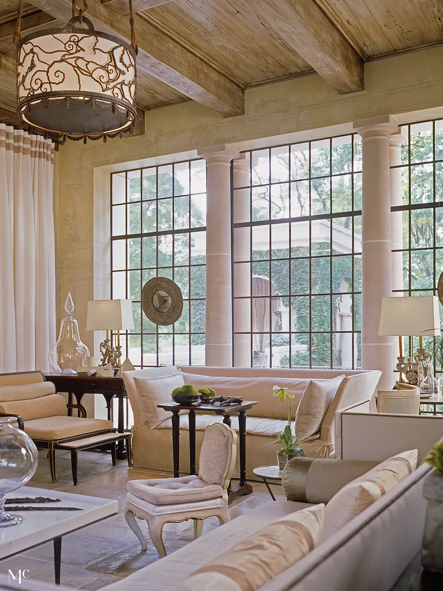 elegant living room with tall windows, a large cream linen sofa and chairs in front of them