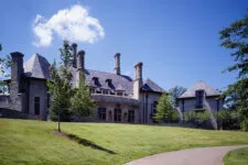 stone and stucco home with a circular wall, front door, French windows, large fluted window sills, bronze light fixtures