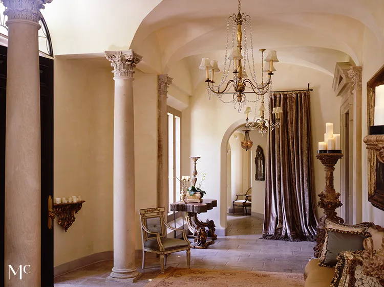 Elegant hallway with tall arched ceilings and white walls, dark wood floors