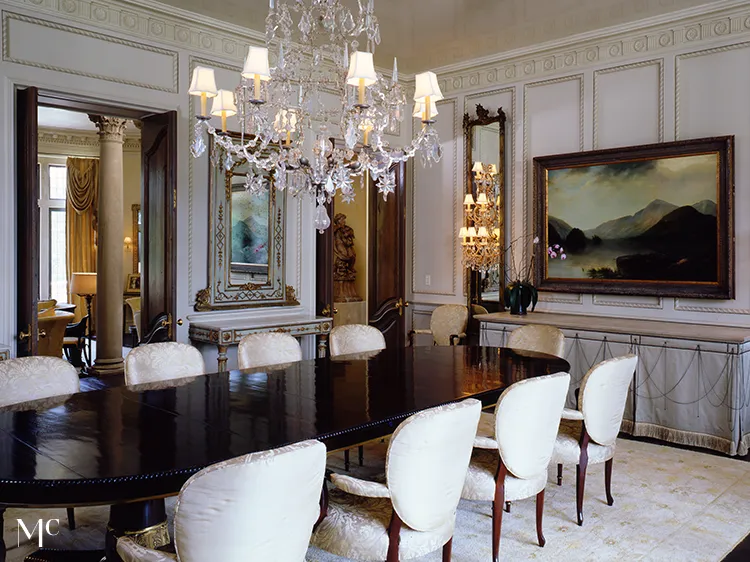 Dining room with tall arched ceilings and white walls, dark wood floors