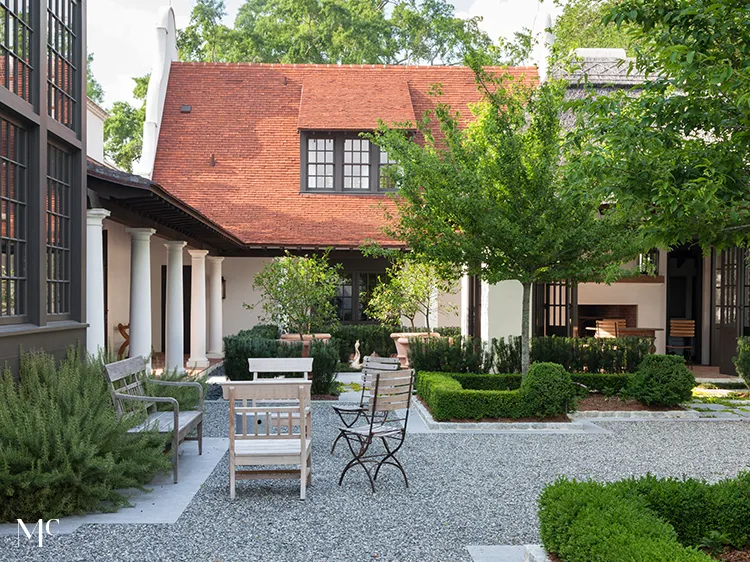 classic colonial-style white house with black shutters, front view, blue door, and large trees in the yard, with navy-blue details, white walls