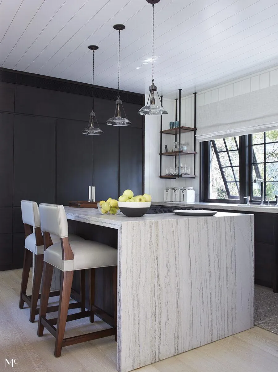 Photo of a kitchen island with bar stools.